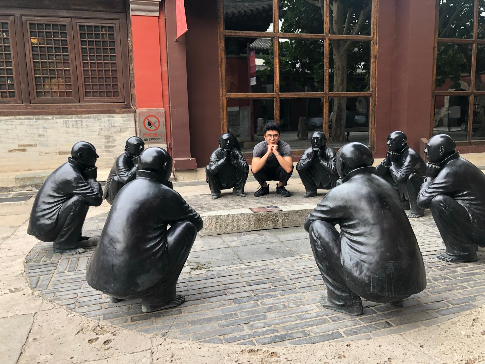 Keanu Arcadio sitting with sculptures